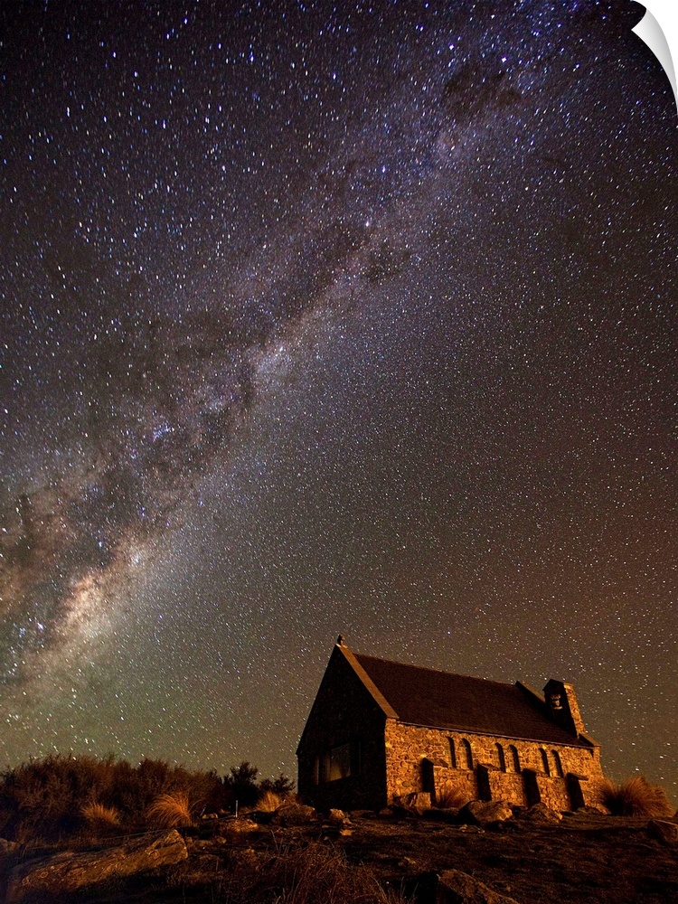 An old church near Lake Tekapo in New Zealand, under a starry night sky.