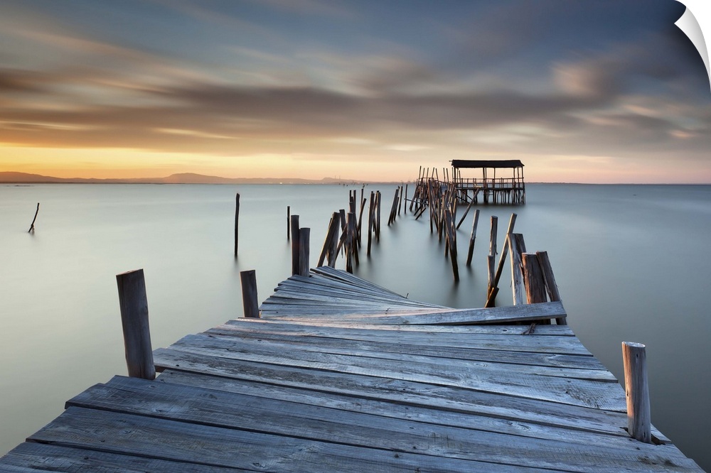 A broken wooden pier off the coast of Carrasqueira, Portugal, at sunset.