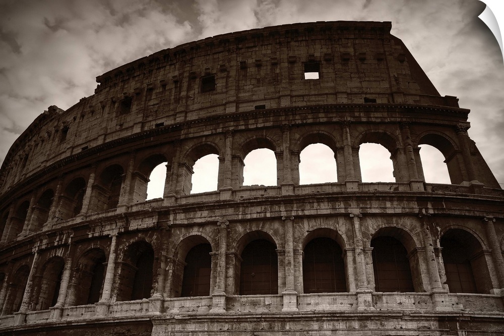 Sepia photograph of the Colosseum in Rome on a cloudy day.