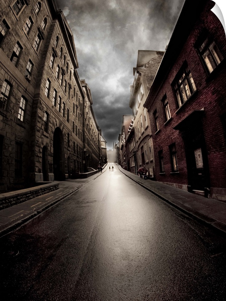 Wide-angle view of a dark street with brick buildings on a cloudy day.
