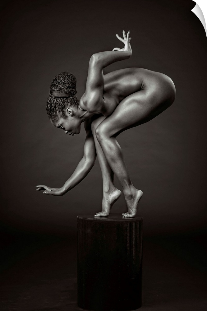 Black and white fine art photograph of an African American woman balancing and posing on a pedestal, resembling a sculpture.