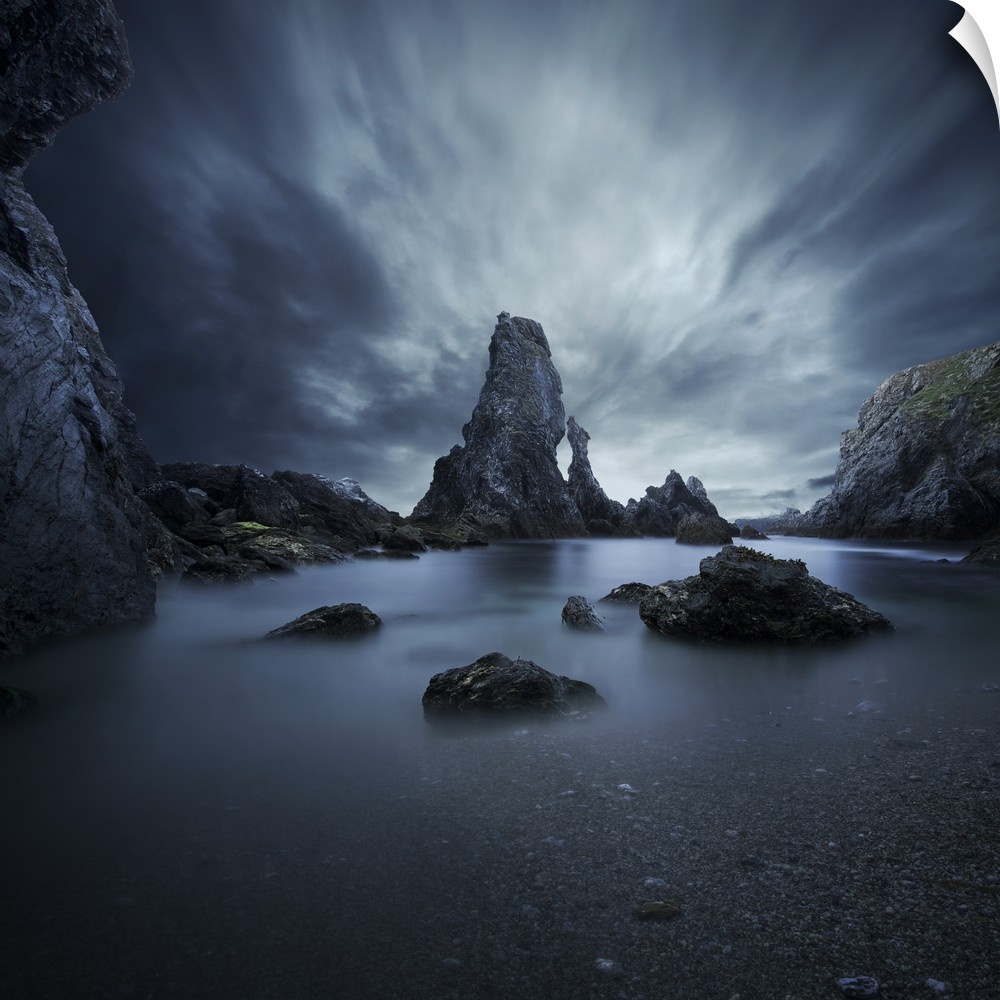 Ethereal landscape of a jagged rock formations and a small tidal pool of smooth water.