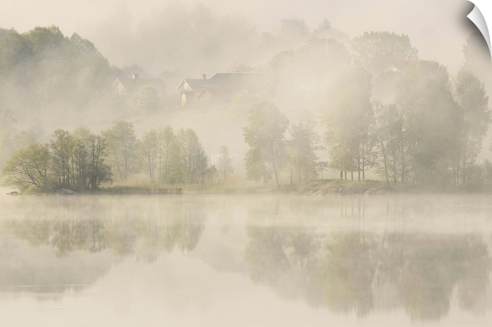 Heavy fog over a lake with houses on the shore, Sweden.
