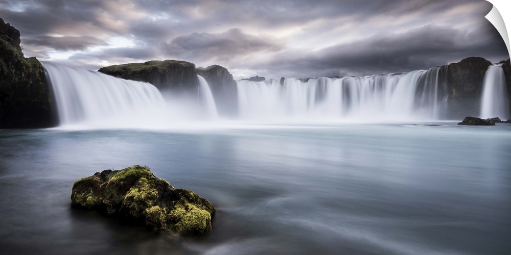 A mossy rock in the water below Godafoss Waterfall, Iceland.