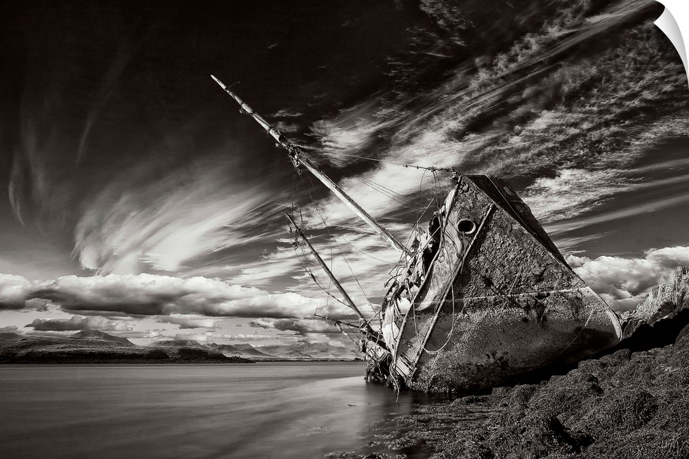 A black and white photograph of a derelict ship washed up on the shores of Iceland.