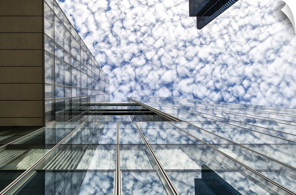 The glass facade of a skyscraper in Brussels reflecting the clouds in the sky.