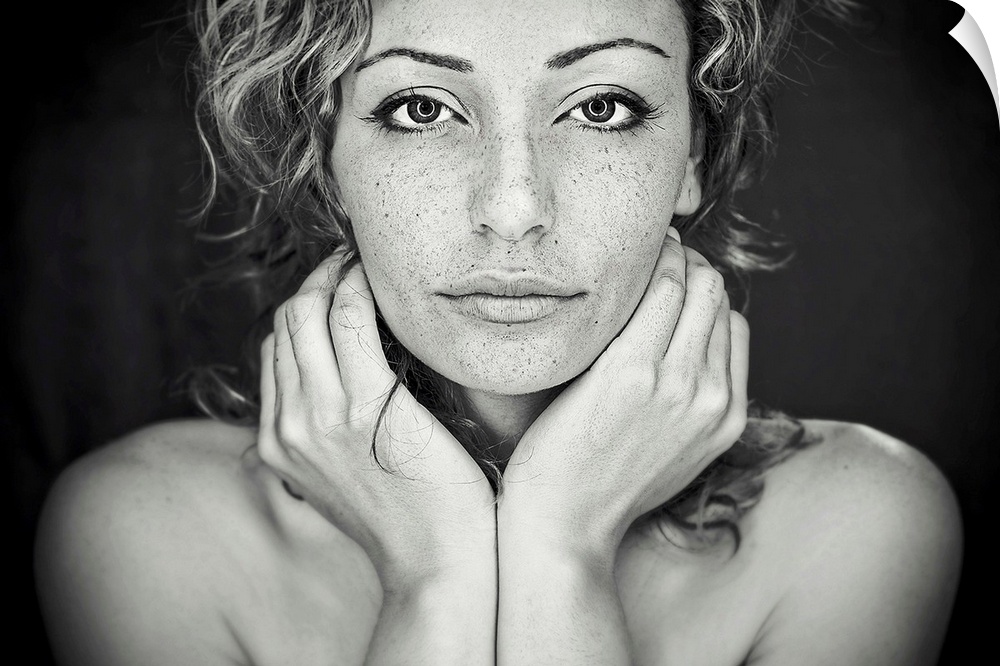 A black and white portrait of a woman with freckles all over her face.