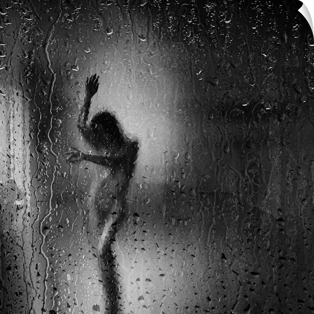 Square black and white fine art photograph of a nude woman through a rainy window glass.