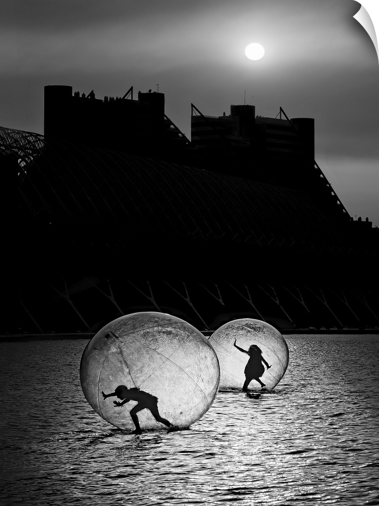 Two human bubbles housing silhouetted figures treading along a watery surface under moonlight.