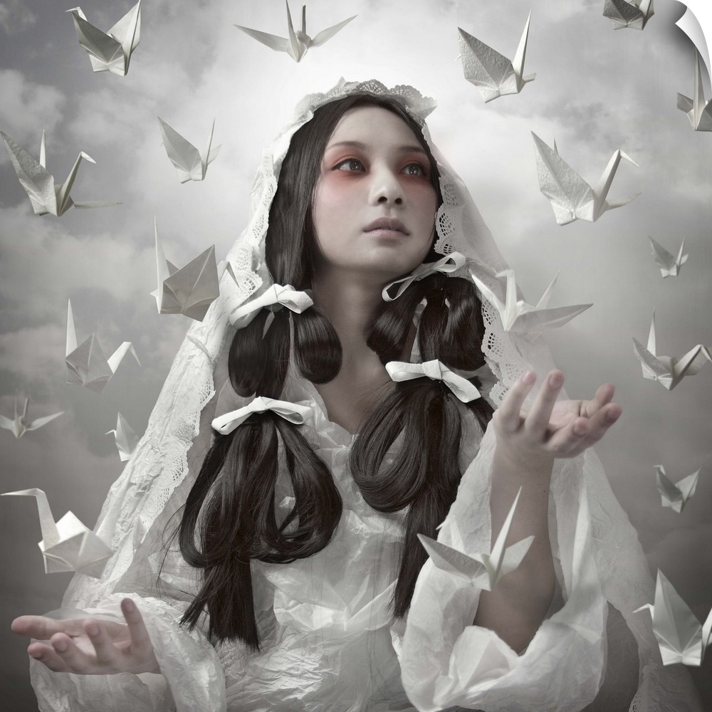 Conceptual image of a beautiful woman in a white robe with paper cranes floating around her.