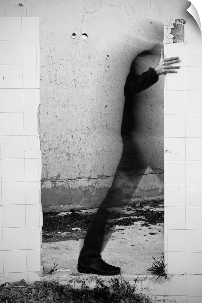 Conceptual photograph of a male figure stepping through a wall.
