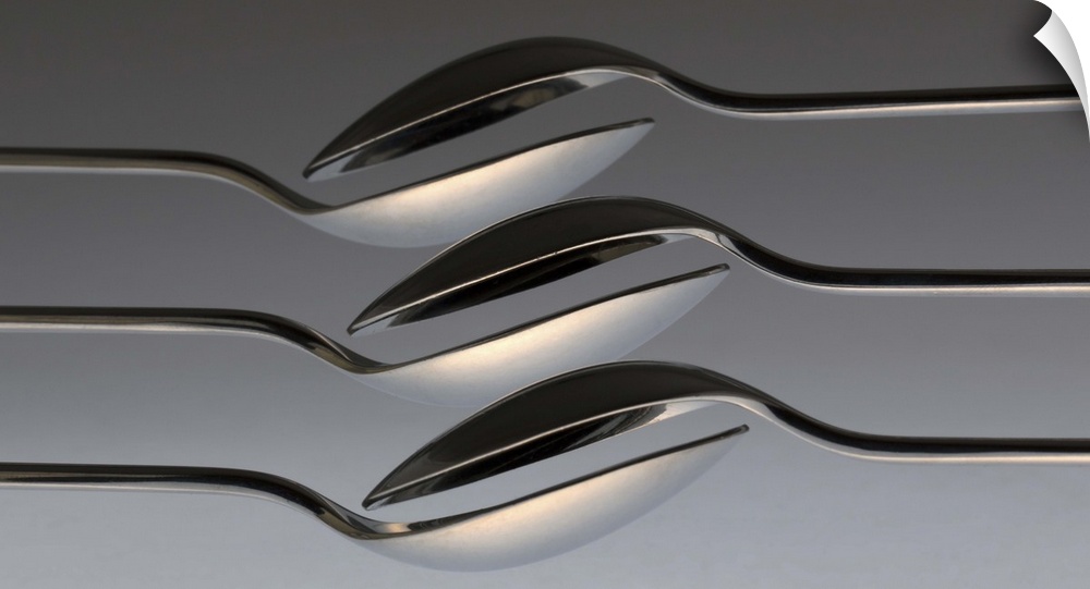 Six spoons arranged to form a wave-like pattern.