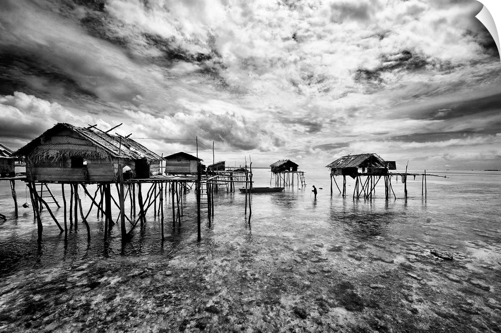 Black and white image of a group of houses on stilts in the ocean, Sabah, Malaysia.