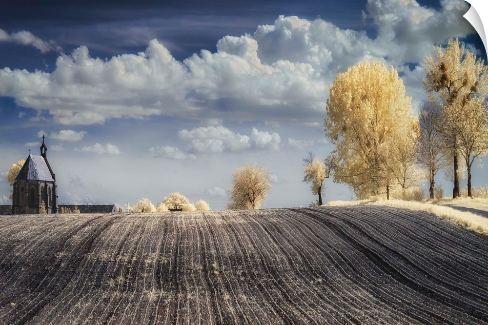 Infrared image of a tilled field in the countryside in Poland, with a church and trees.
