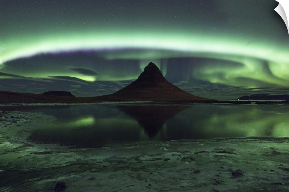 Swirling and glowing northern lights above Kirkjufell Mountain in Iceland.