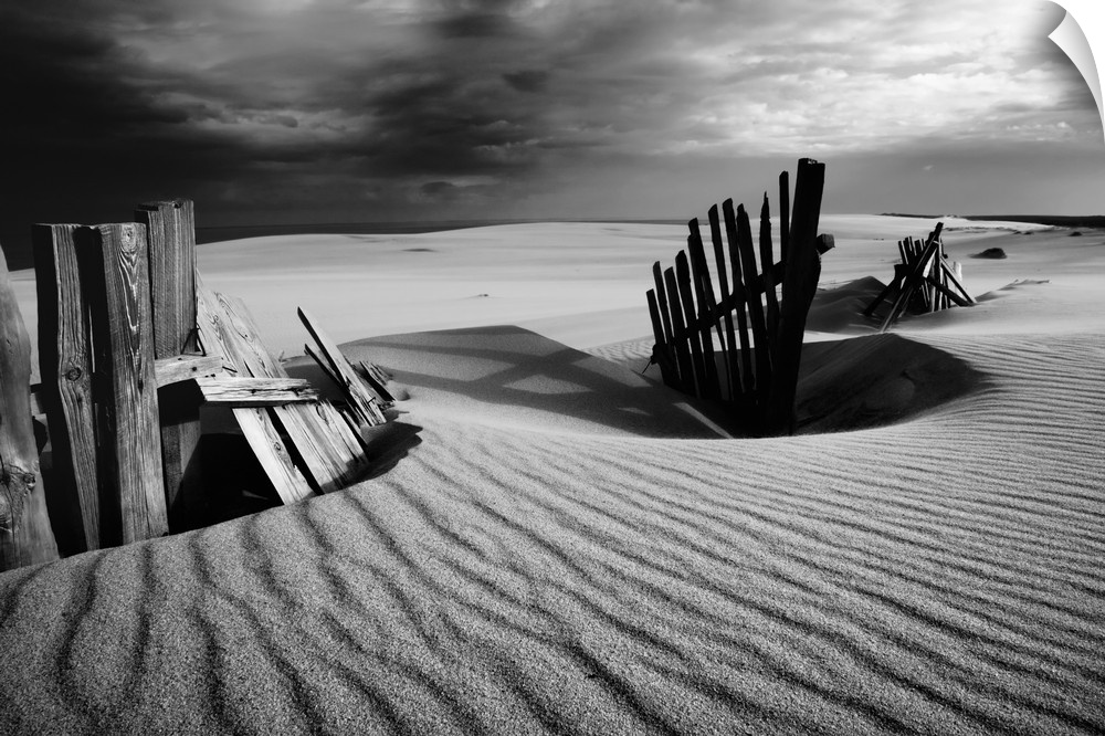 Black and white photograph of a fence at the White Sands dunes in the Curonian Spit.