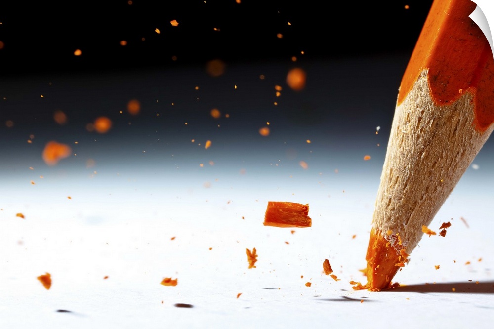 Close up image of the lead of an orange colored pencil shattering.