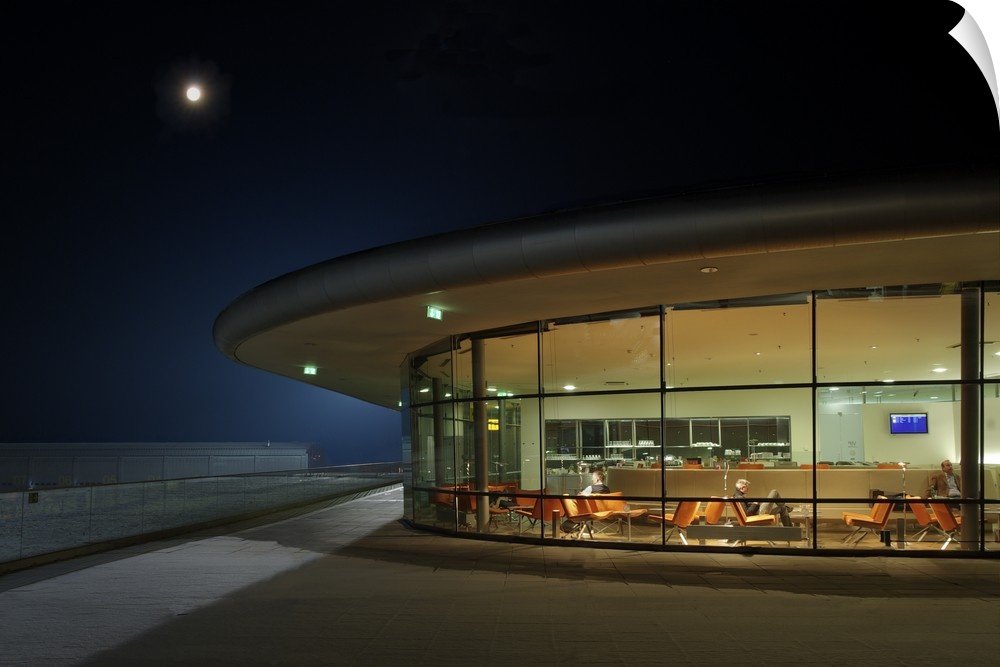 A round lounge lit up in the evening, with people seated inside.