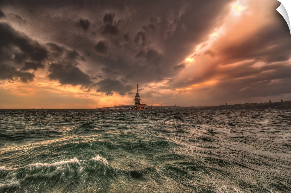 Lighthouse connecting the sea and the clouds above at sunset.