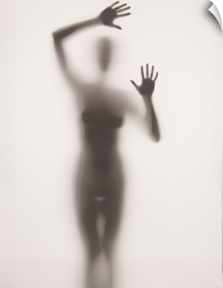Fine art photograph of  nude female figure behind frosted glass.
