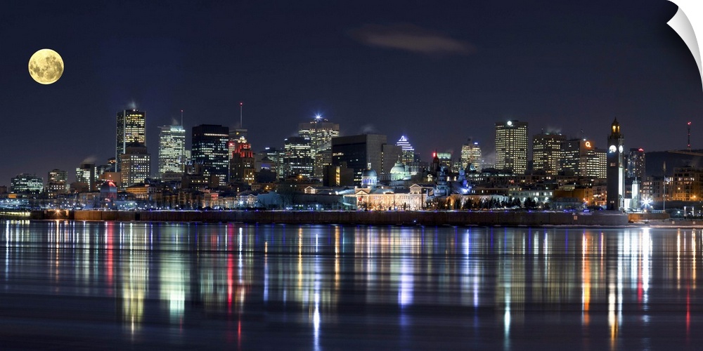 Colorful city lights of the Montreal skyline reflected in the water at night.