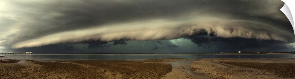 Panoramic image of a beach with a thick wall of stormclouds approaching.