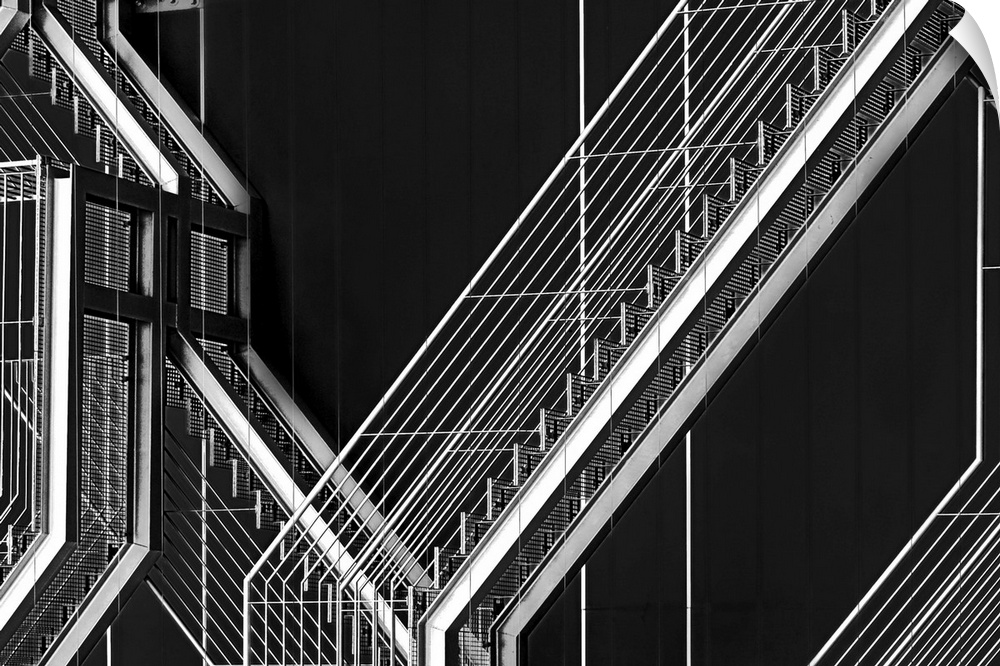 High contrast black and white image of an outdoor staircase against the dark facade of a building.