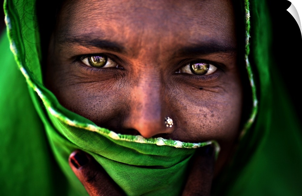 A portrait of a woman with most of her face covered by a green wrap.