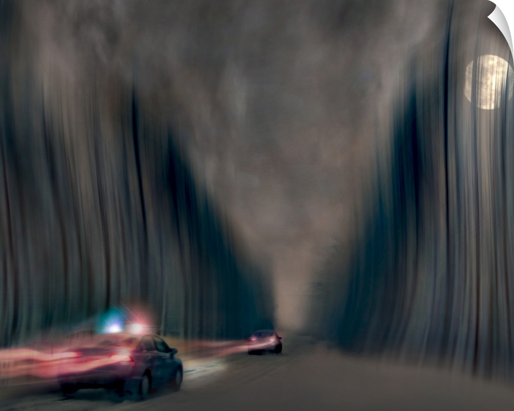 Blurred motion image of a police car chasing a speeding vehicle.