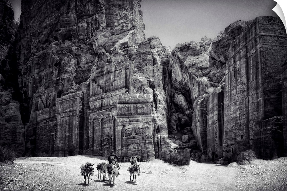 People with donkeys in front of the temple at Petra, Jordan, in the desert.