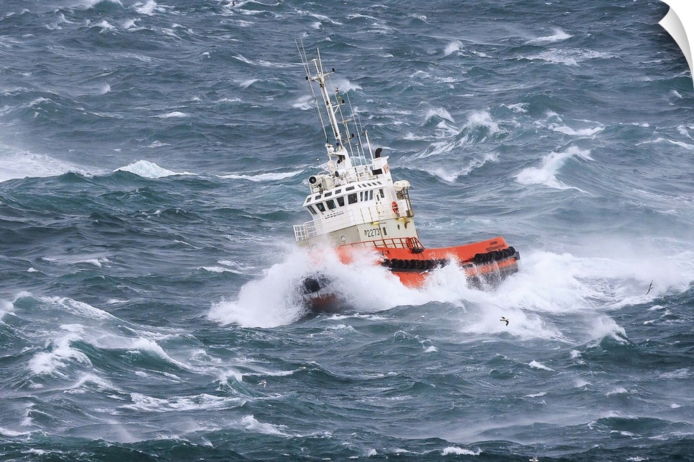 A tugboat navigates the rough ocean waves off the Icelandic coast.