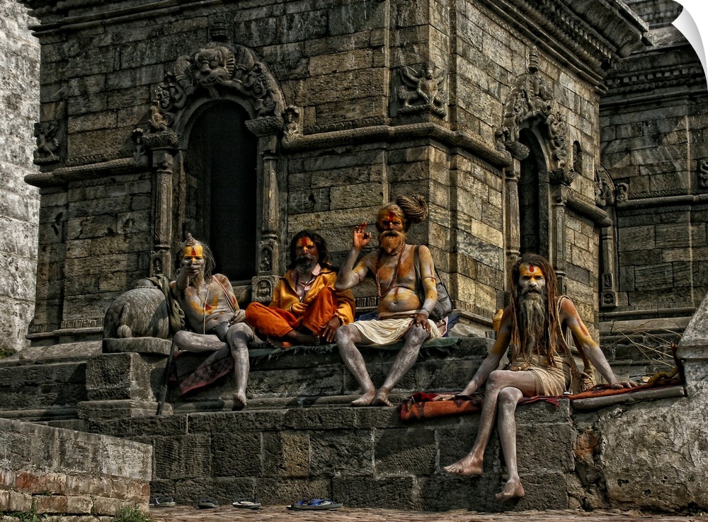 A group of men with bodypaint sitting at a temple during a festival.