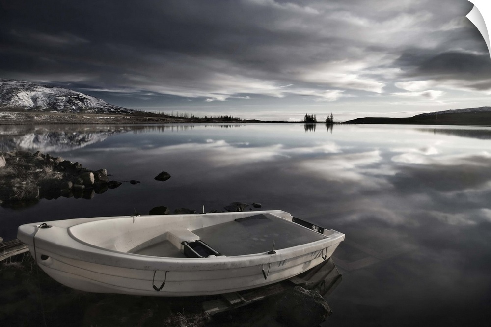 A small boat on the edge of a still lake, Iceland.