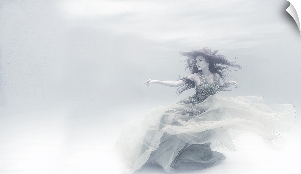 Underwater portrait of a woman in a flowing dress, in soft white light.