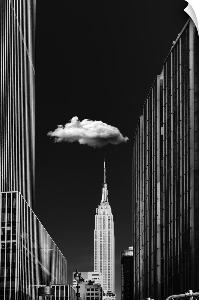 Black and white photograph of a New York City cityscape highlighting the single cloud hanging over the Empire State Building.