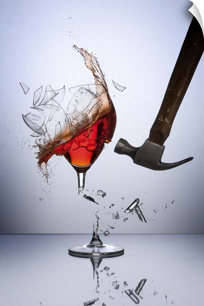 A hammer smashing a glass of wine, sending glass shards flying.