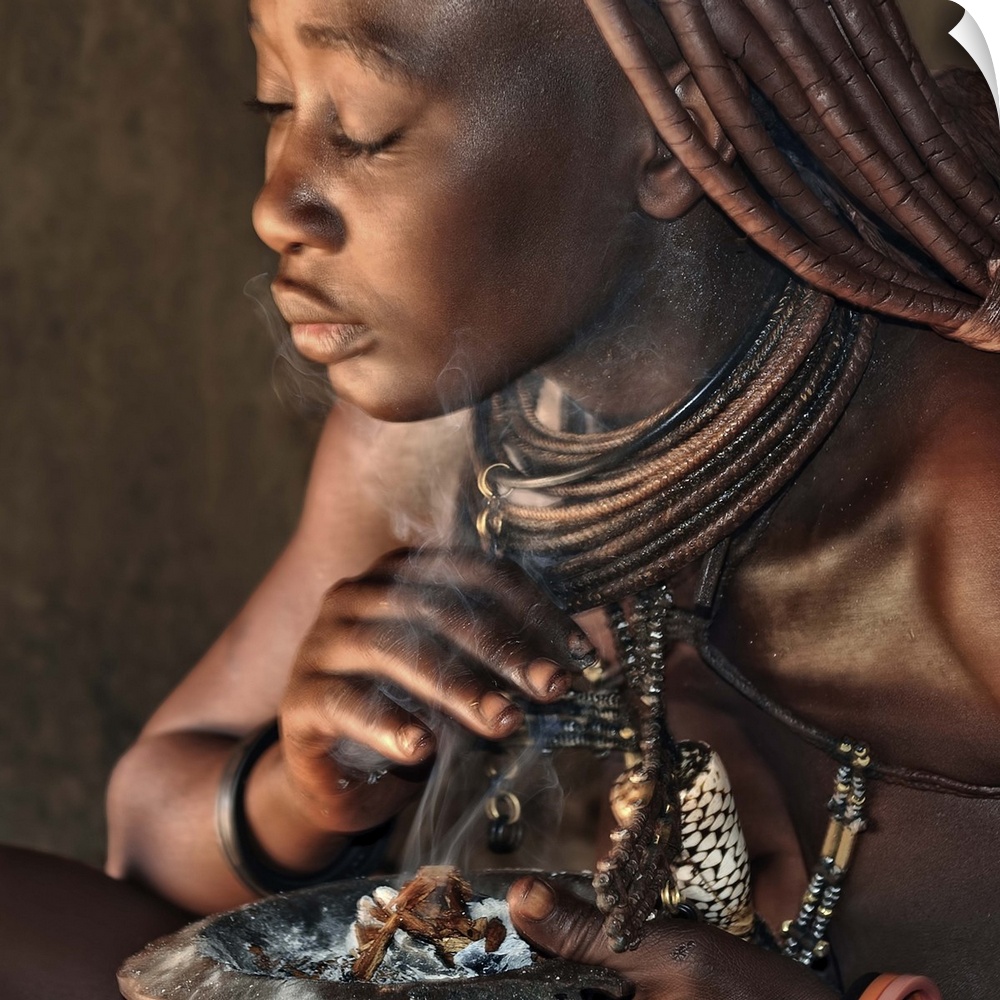 An African tribeswoman baths herself in smoke from various herbs.