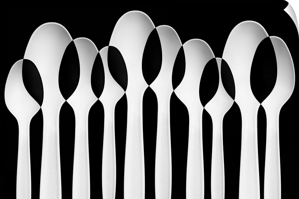Spoons standing in a row, with negative space where they intersect.