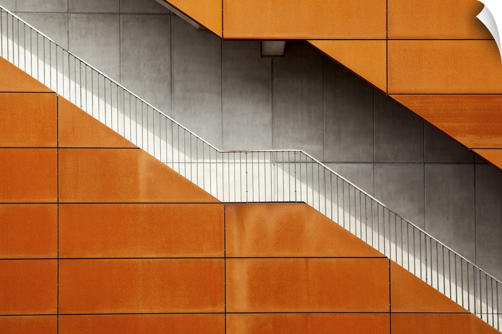 A stairway cutting through an building with an orange facade, Amsterdam.