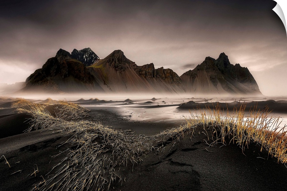 A jagged mountain range in a black sand valley in Iceland.