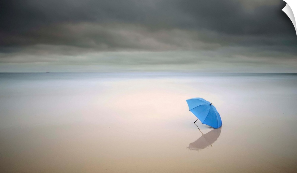 A blue umbrella resting on the beach under a cloudy sky, Carcavelos, Portugal.