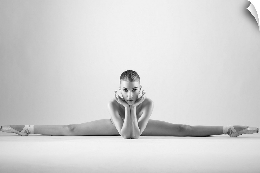 A ballerina in a split pose with toes pointed outwards.