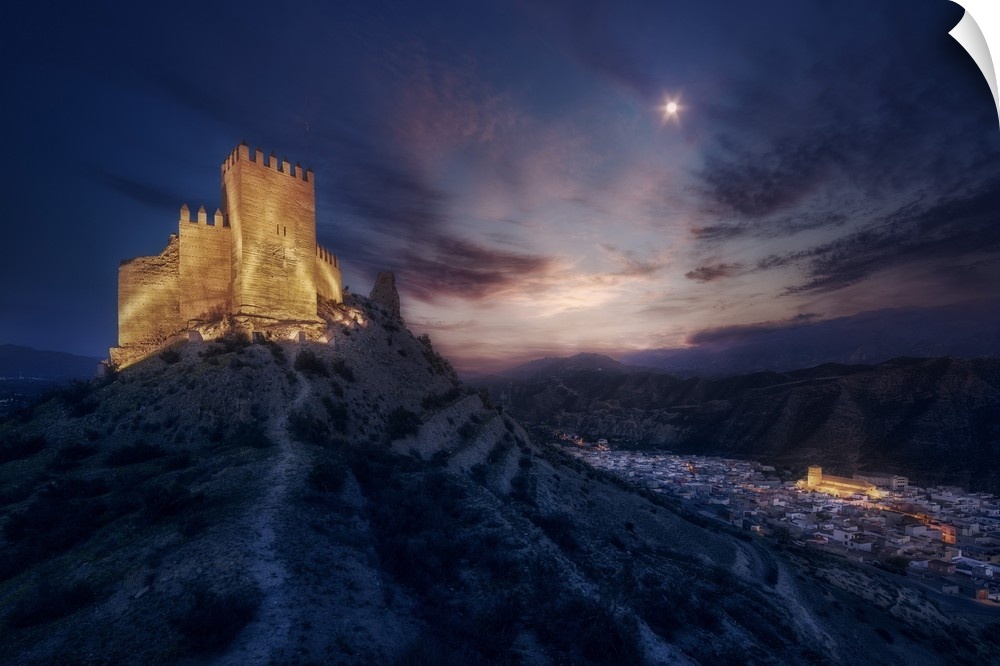 A castle on a mountain illuminated at night in Andalusia, Spain.