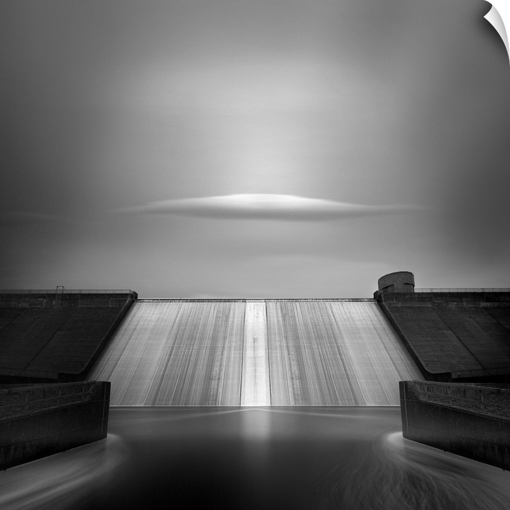 A single cloud floats above the spillway of a large dam.