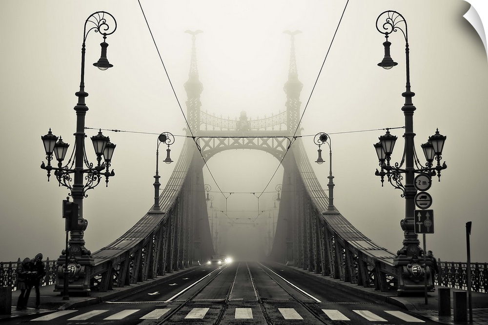 Ornate iron street lamps stand at the entrance to a bridge in Budapest, Hungary.