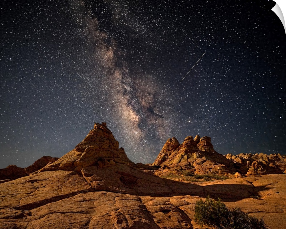 Rock formations in the desert of Coyote Buttes, Arizona, under a starry night sky.
