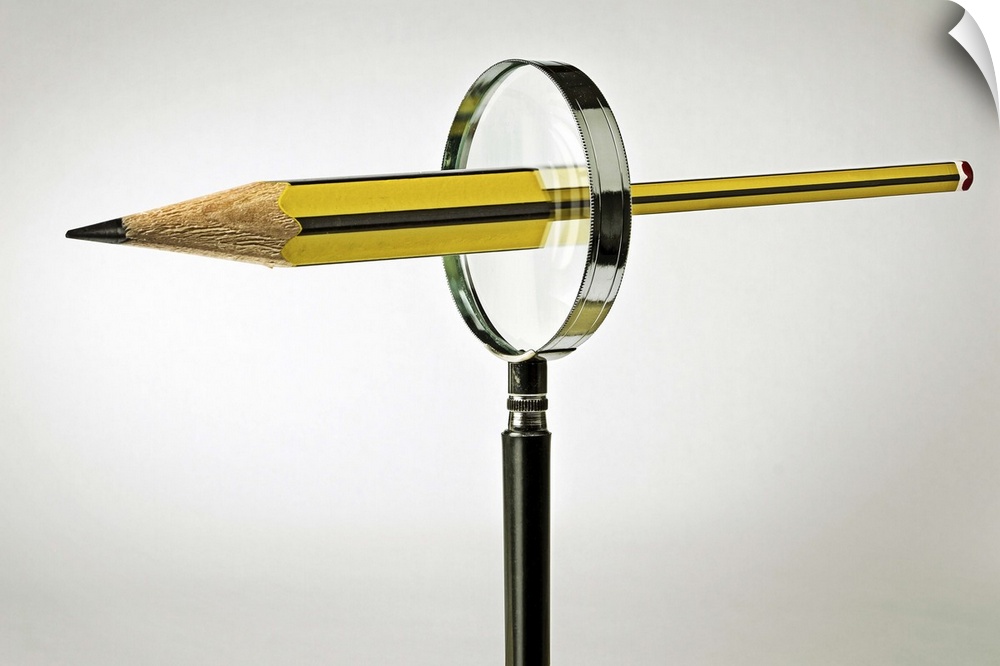 Conceptual image of a pencil passing through a magnifying glass, emerging bigger on the other side.