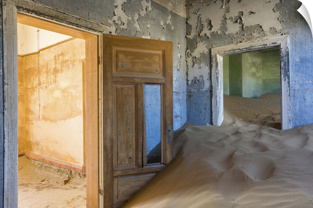 Photograph of an abandoned home interior now filled with the desert sand.