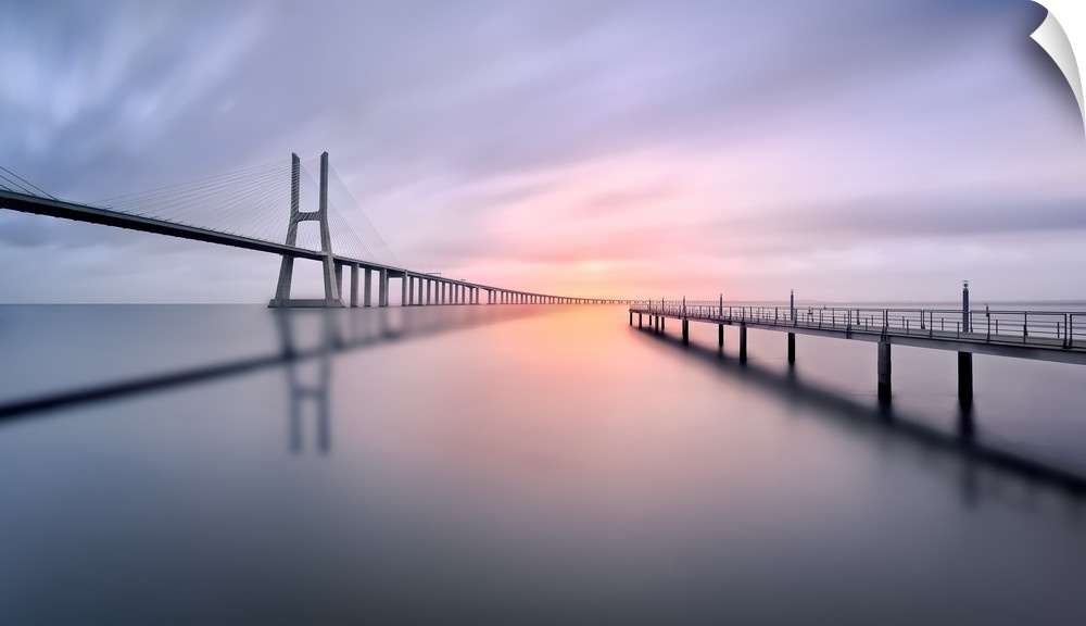 A serene view of a bridge curving into a bend in the distance with a pier to the side jetting out into the water.