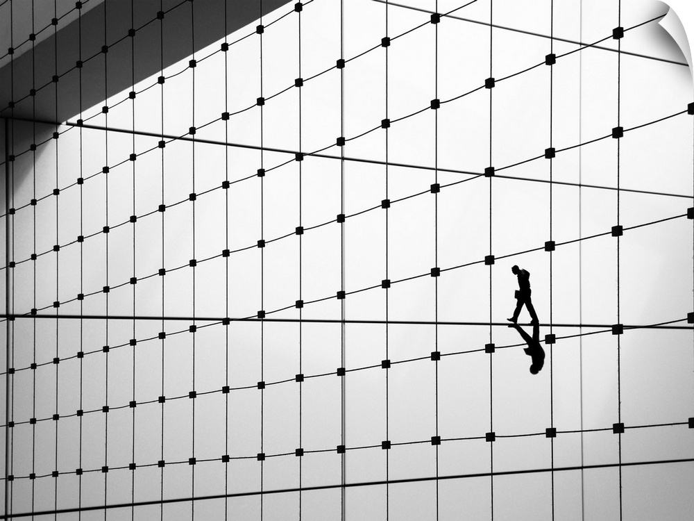 Conceptual image of a person walking on a thin line, one of many on the side of a building.